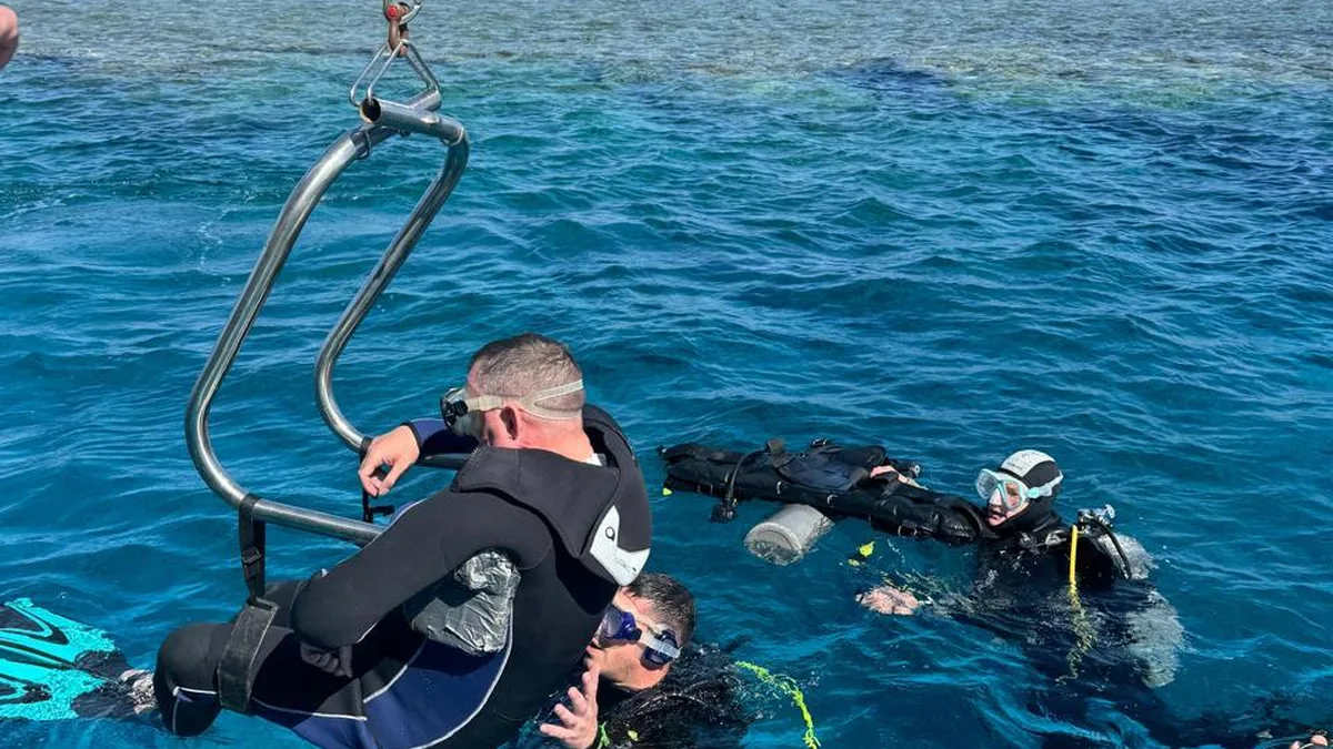 An instructor patiently guiding a diver with a disability through a skill in calm, shallow water