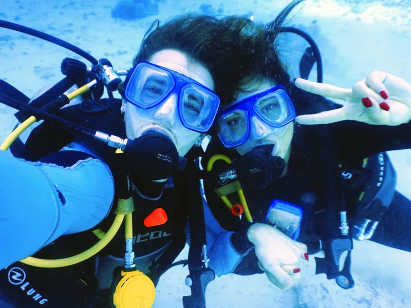 Two scuba divers taking a happy underwater selfie in the Red Sea