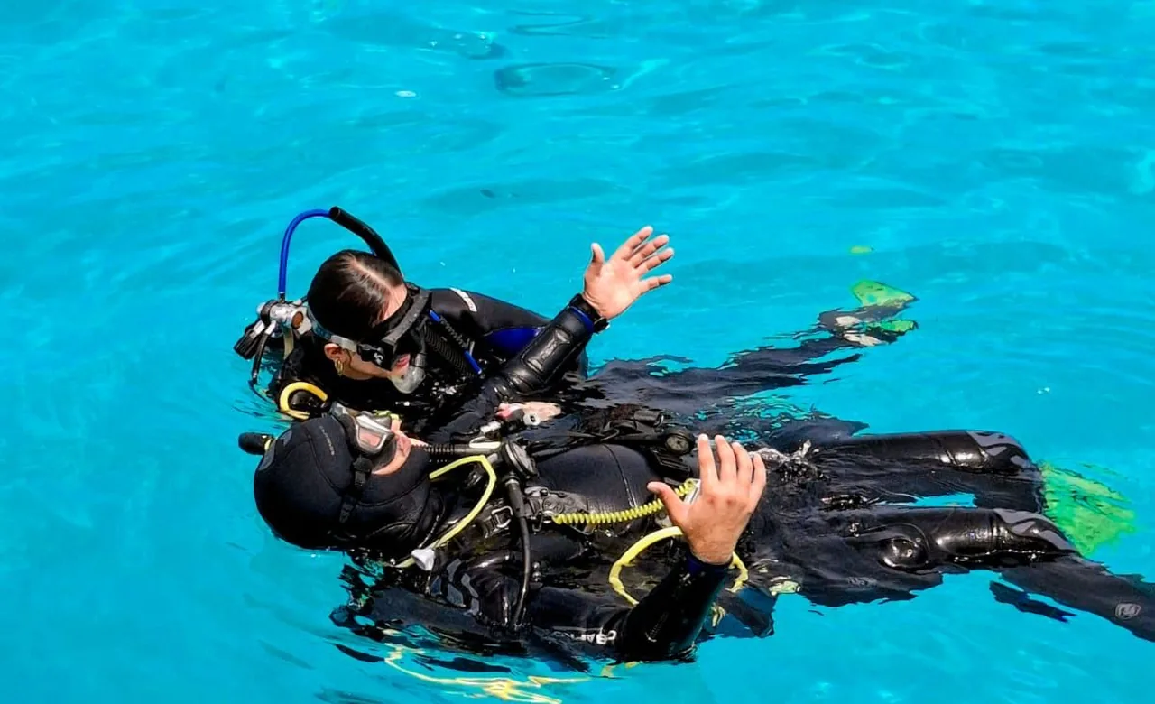 Un instructeur de plongée guidant un élève à travers les exercices en eau calme et peu profonde